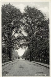 <p>Foto van voor de Tweede Wereldoorlog waarop te zien is dat de Deventerweg verbreed is en de binnenste bomenrij aan de Deventerweg verdwenen is. Kennelijk zijn de eerste twee bomen van de binnenste rijen achter de brug gespaard gebleven. Deze zijn waarschijnlijk gesneuveld bij het opblazen van de brug in 1940 (Regionaal Archief Zutphen). </p>
